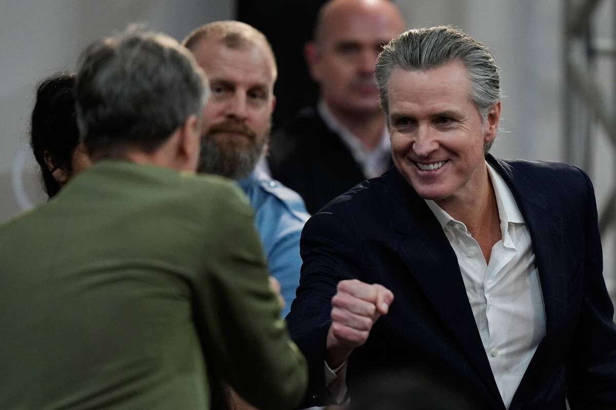 California Gov. Gavin Newsom, right, greets people as he arrives for a news conference at the C ...