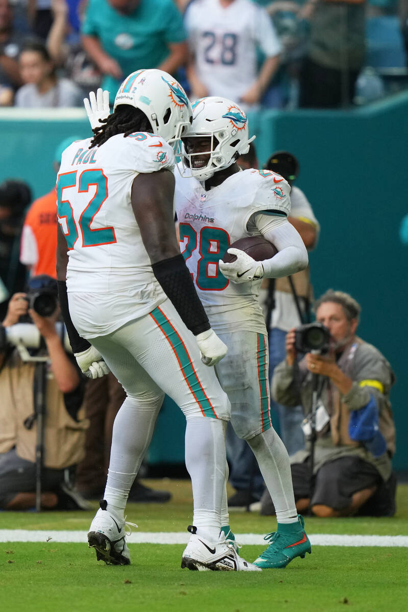 Miami Dolphins running back De'Von Achane (28) celebrates with Patrick Paul (52) after sco ...