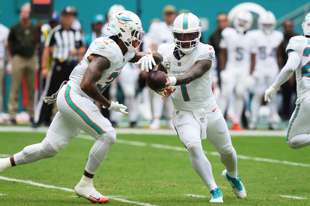 Miami Dolphins quarterback Tua Tagovailoa (1) hands off the football to running back Ollie Gord ...