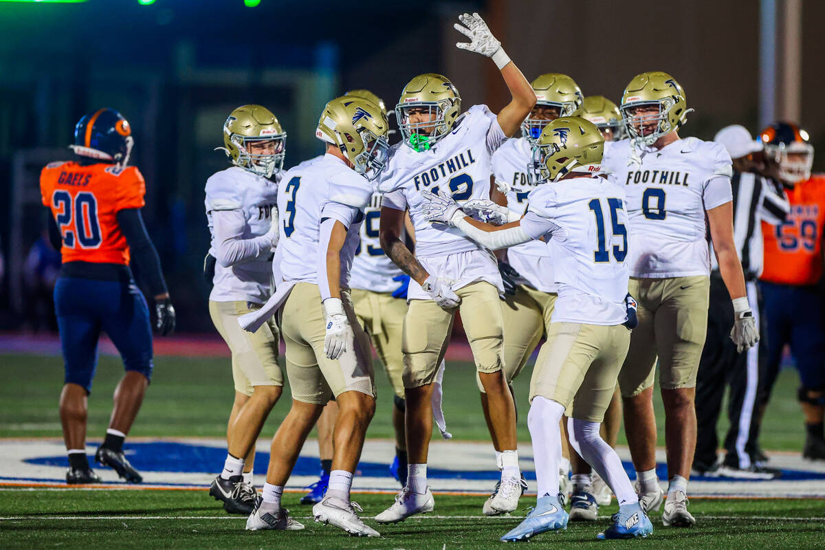Foothill teammates celebrate a sack during a Open Division high school football playoff game be ...