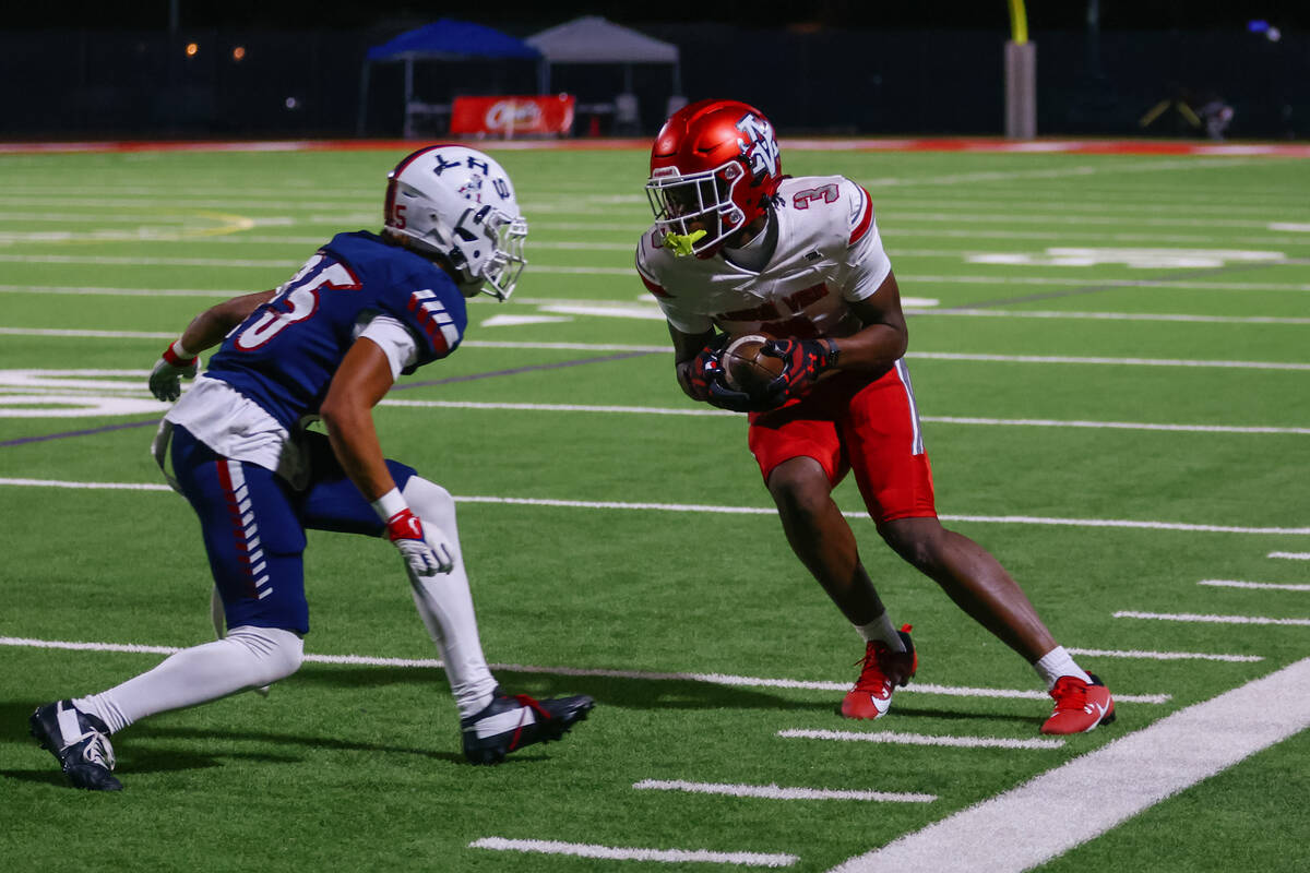 Arbor View wide receiver Damani Warren (3) tries to find a way around Liberty defensive back Na ...