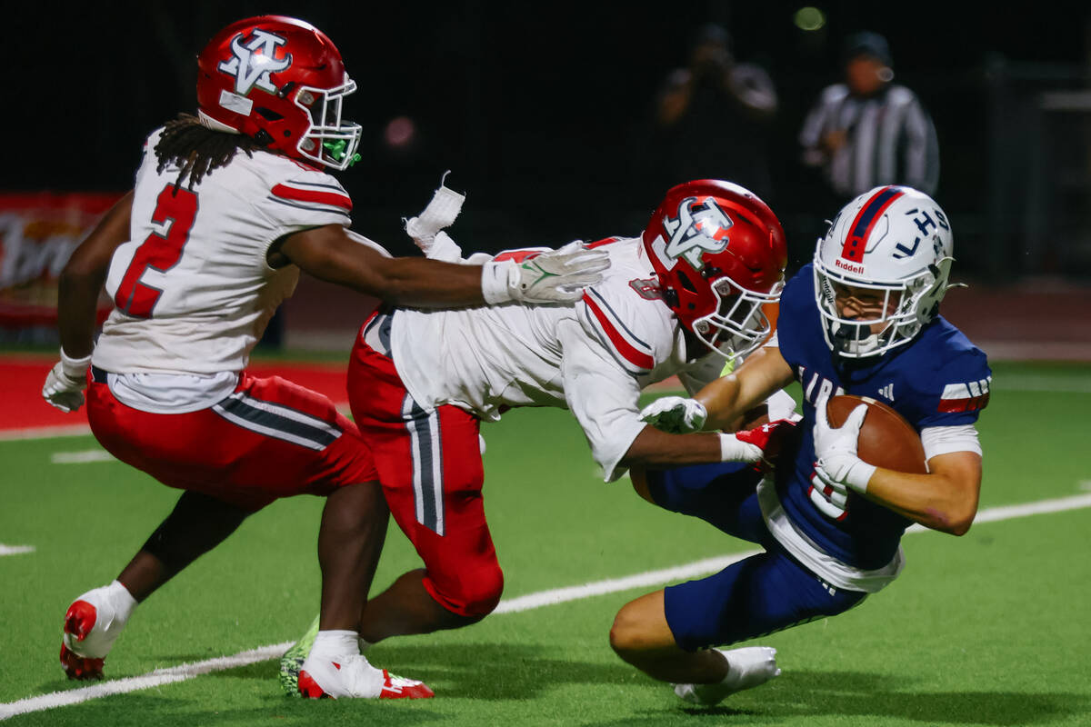 Arbor View strong safeties Nylen Johnson (2) and Kamareion Bell (0) tackle Liberty wide receive ...
