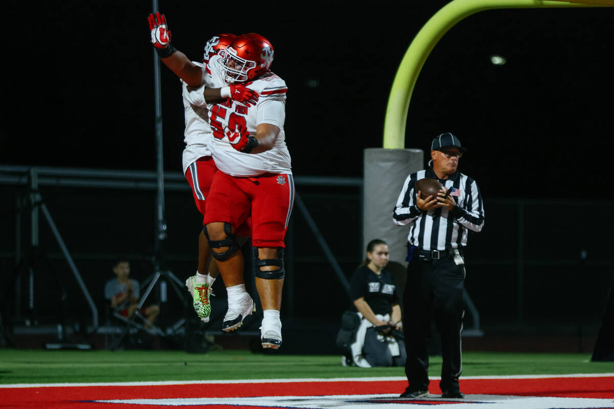 Arbor View guard Anthony Beltran (56) and running back Kamareion Bell (0) celebrate TK’s ...