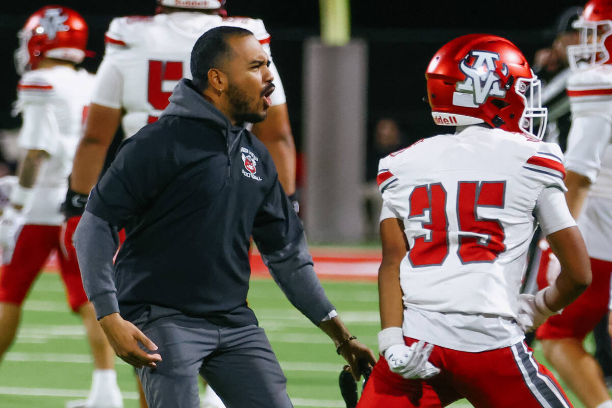 Arbor View coach LJ Holmes celebrates with cornerback Michael Miniano (25) after Miniano made a ...