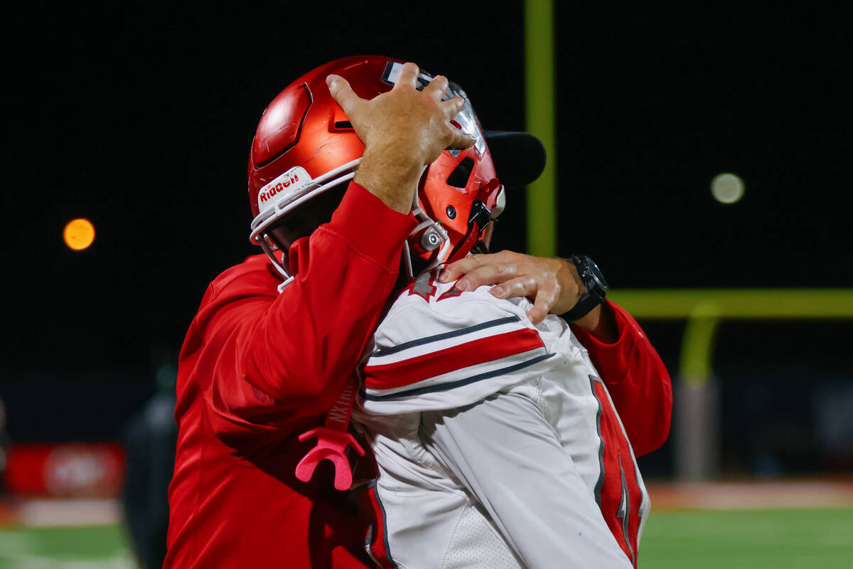 Arbor View assistant coach Beau Vinatieri embraces defensive end Aisek Brown(47) during the ope ...