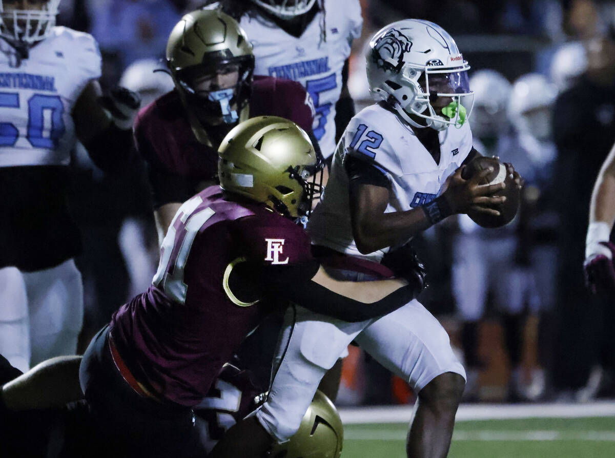 Centennial quarterback Nehemiah Dunlap-myvett (12) is sacked by Faith Lutheran defensive line A ...