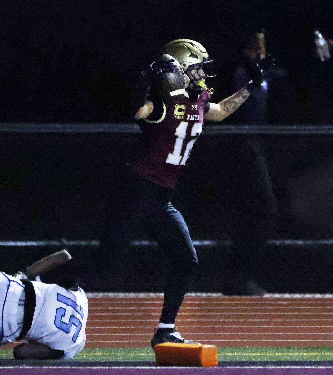 Faith Lutheran wide receiver Aipa Kuloloia (12) scores a touchdown as Centennial cornerback For ...