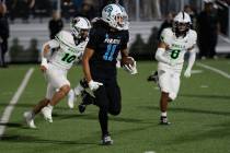 Sloan Canyon wide receiver Justice Hutchins (11) makes his way around defenders during the 4A S ...