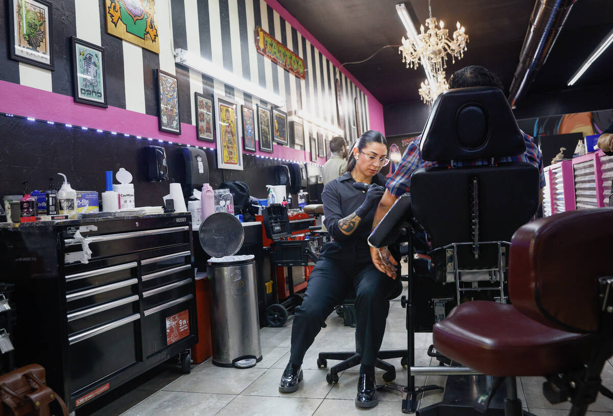 iA tattoo artist works on a client at Koolsville Tattoos’ Arts District location along M ...