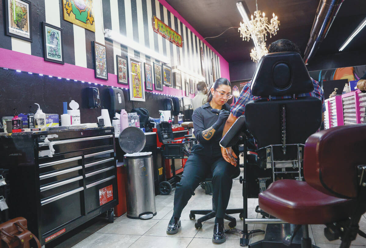 iA tattoo artist works on a client at Koolsville Tattoos’ Arts District location along M ...