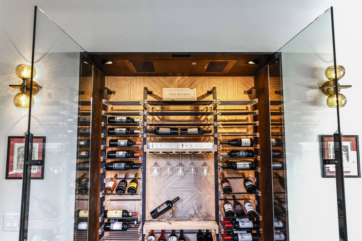 A refrigerated wine room with metal and acrylic wince racks by Las Vegas Wine Cellars is photog ...
