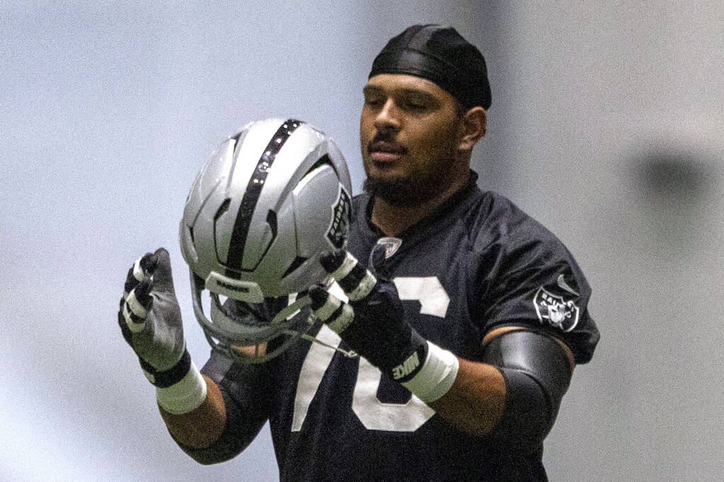 Raiders guard Caleb Rogers (76) puts on his helmet during the team’s practice at the Int ...