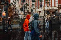 Pedestrians take cover from the rain on the Strip Saturday, Nov. 15, 2025, in Las Vegas. (Madel ...