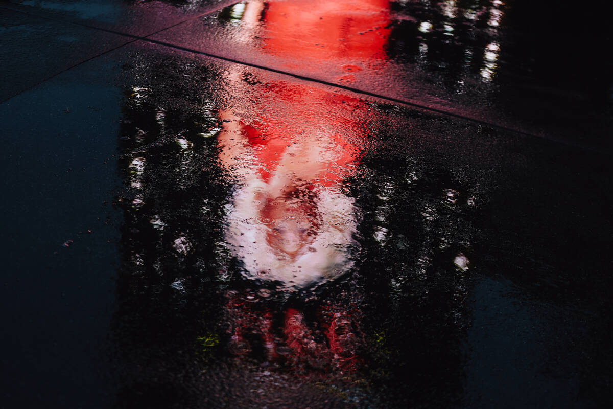 An ad for Rupaul’s show at the Flamingo is reflected in a puddle from the rain on the St ...