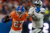 Raiders linebacker Devin White (45) is stiff armed by Denver Broncos running back J.K. Dobbins ...