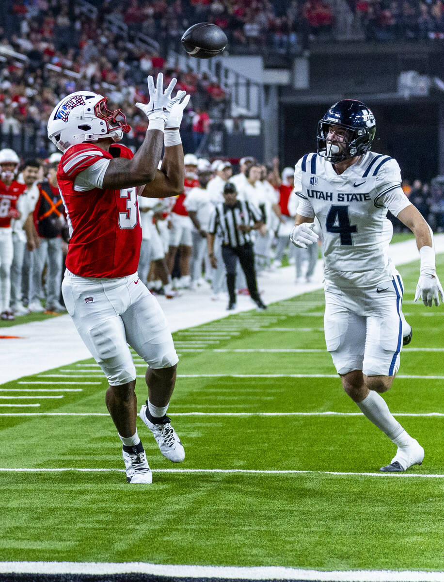 UNLV tight end Var'Keyes Gumms (30) looks in a long pass as Utah State Aggies safety Brevi ...
