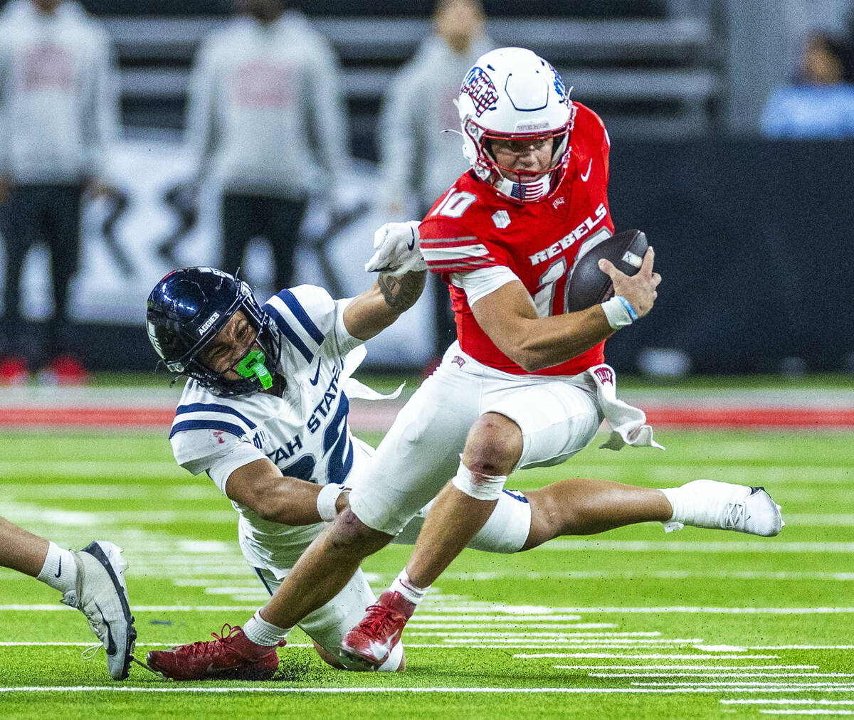 UNLV quarterback Anthony Colandrea (10) cuts back on a run leaving Utah State Aggies safety Cha ...