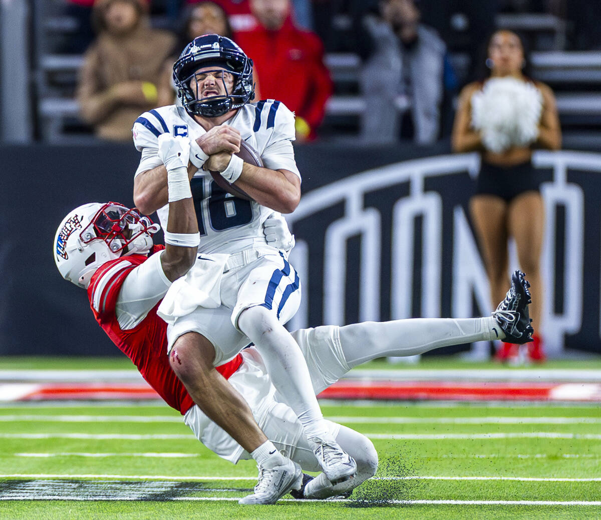 Utah State Aggies quarterback Bryson Barnes (16) is stopped on a run by a hard hit from UNLV de ...