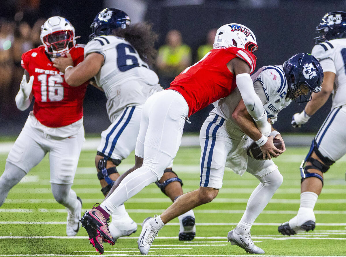 UNLV linebacker Chief Borders (1) sacks Utah State Aggies quarterback Bryson Barnes (16) during ...