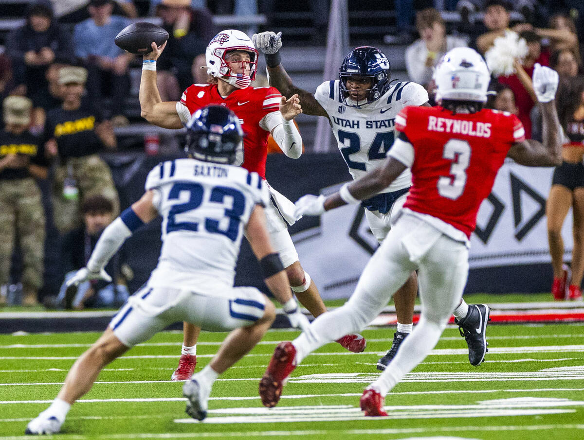UNLV quarterback Anthony Colandrea (10) looks to pass under pressure by Utah State Aggies defen ...