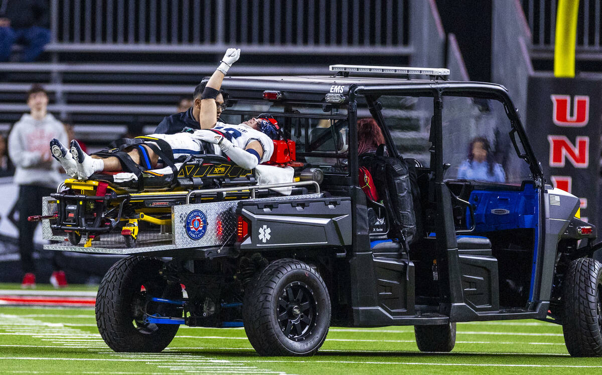 Utah State Aggies safety Titan Saxton (23) lifts a fist into the air as fans cheer, he injured ...