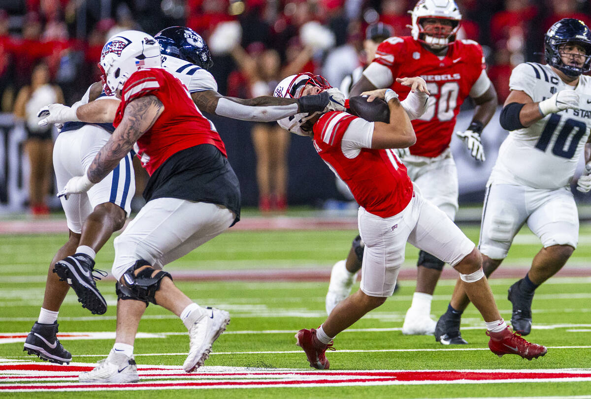 UNLV quarterback Anthony Colandrea (10) is pulled down from under his chin by Utah State Aggies ...