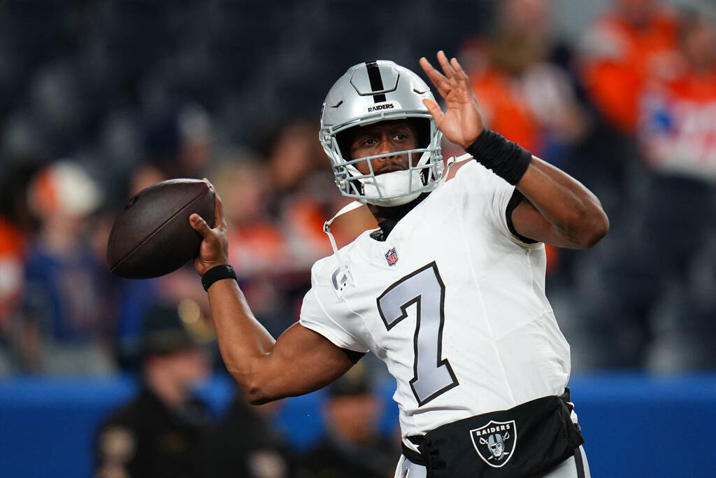 Las Vegas Raiders quarterback Geno Smith warms up against the Denver Broncos during an NFL foot ...
