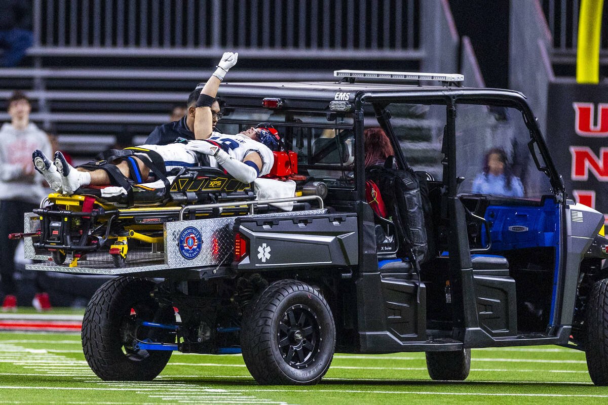 Utah State Aggies safety Titan Saxton (23) lifts a fist into the air as fans cheer, he injured ...