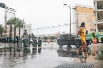 Pedestrians take cover from the rain on the Strip Saturday, Nov. 15, 2025, in Las Vegas. (Madel ...