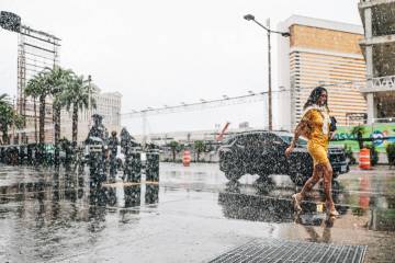 Pedestrians take cover from the rain on the Strip Saturday, Nov. 15, 2025, in Las Vegas. (Madel ...