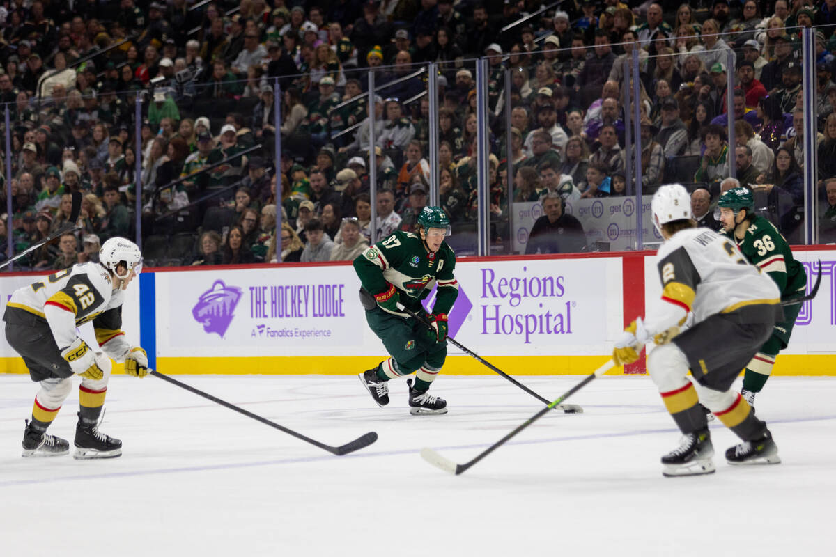 Minnesota Wild player Kirill Kaprizov, center, controls the puck against the Vegas Golden Knigh ...