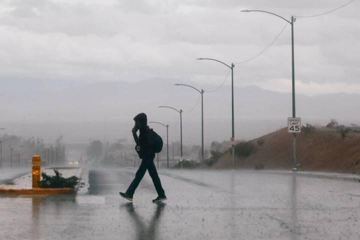 A pedestrian crosses Mountain Vista Street in the rain on Tuesday, Nov. 18, 2025 in Henderson. ...