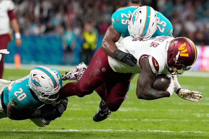 Washington Commanders wide receiver Deebo Samuel (1) is tackled by Miami Dolphins linebacker Jo ...