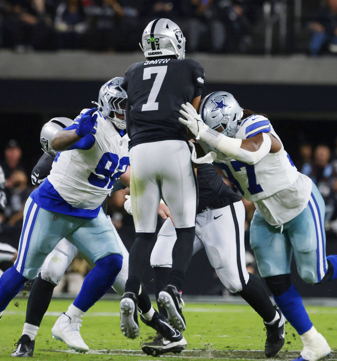 Raiders quarterback Geno Smith (7) is sacked by Dallas Cowboys defensive tackle Quinnen William ...