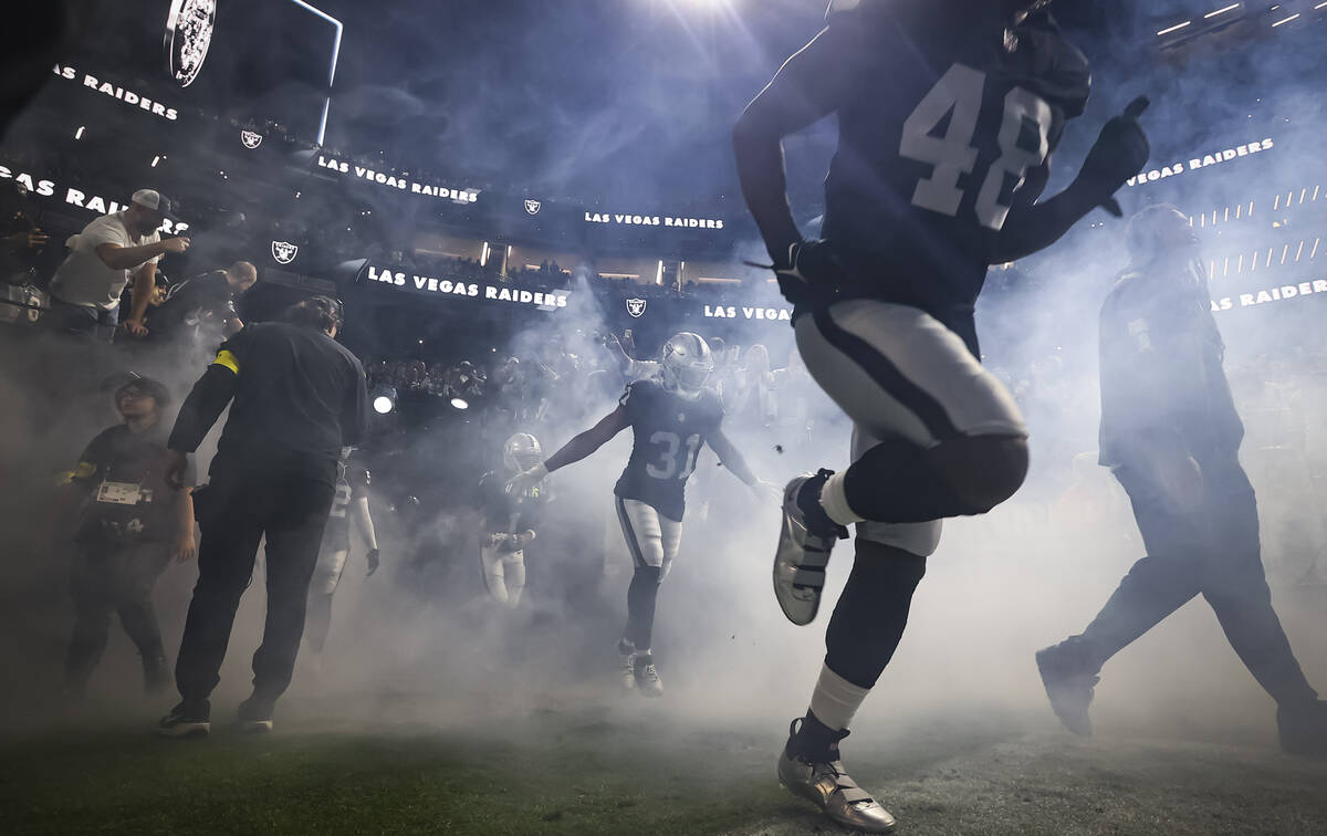 Raiders players run onto the field before the start of a “Monday Night Football" NF ...