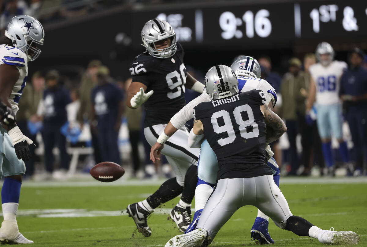 Raiders defensive end Maxx Crosby (98) forces Dallas Cowboys quarterback Dak Prescott (4) to fu ...