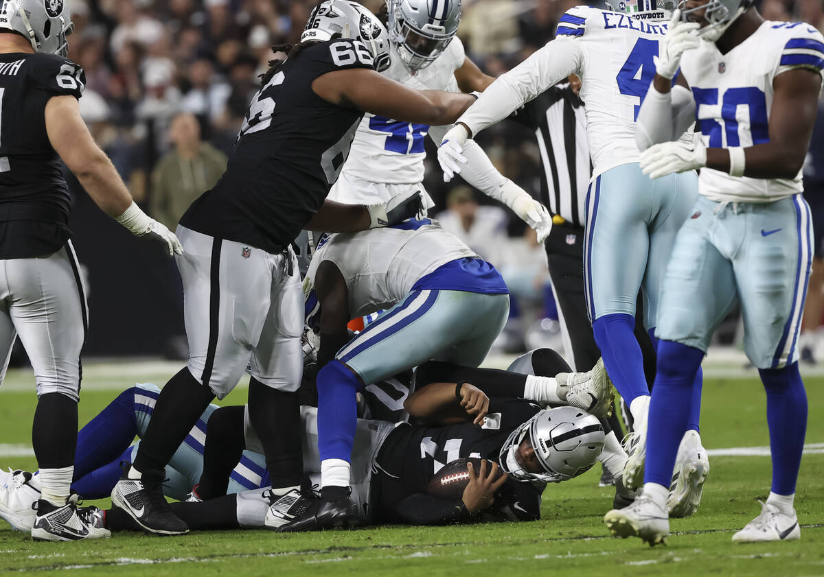 Raiders quarterback Geno Smith (7) gets sacked by the Dallas Cowboys during the first half of a ...