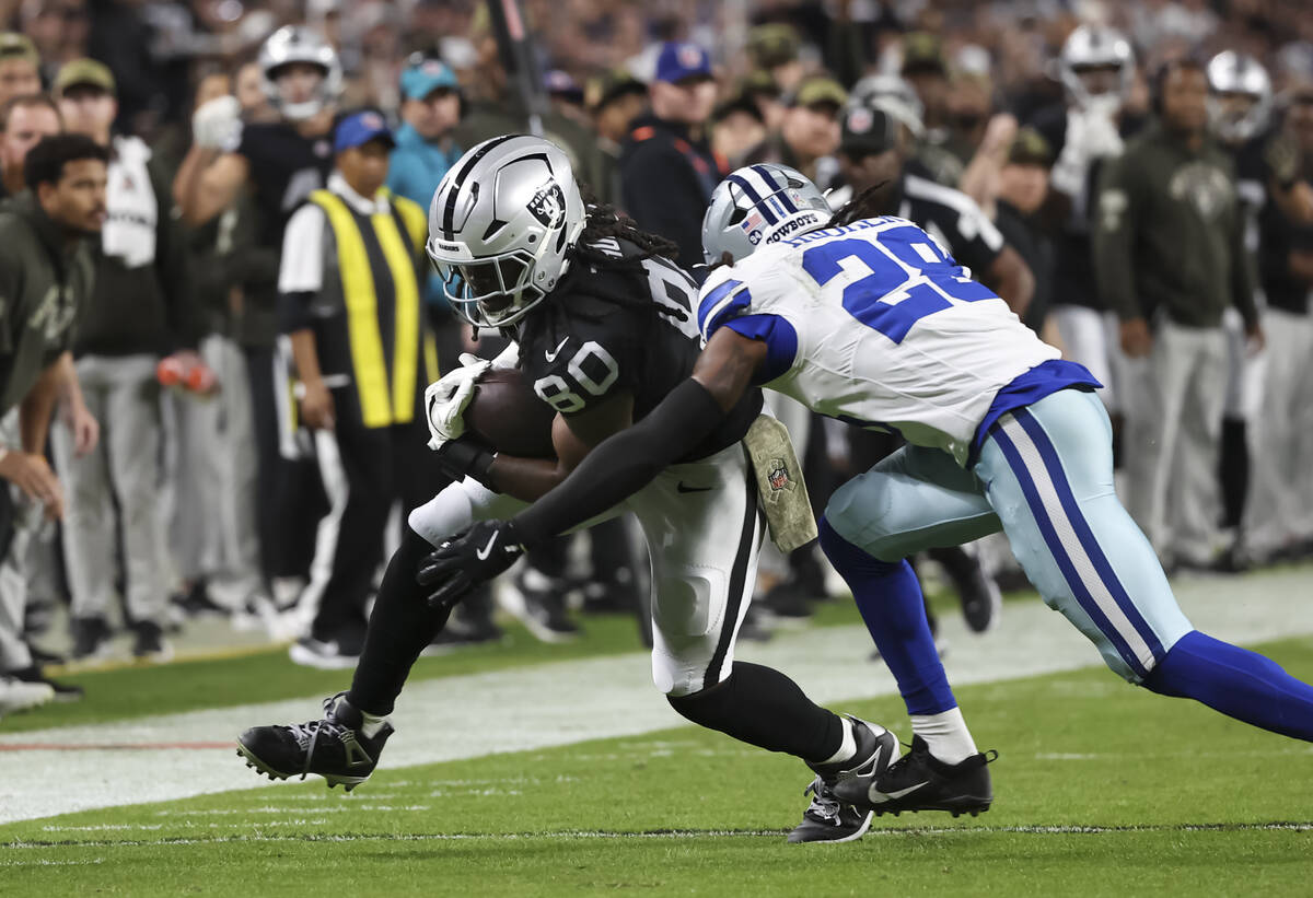 Dallas Cowboys free safety Malik Hooker (28) tackles Raiders tight end Ian Thomas (80) during t ...