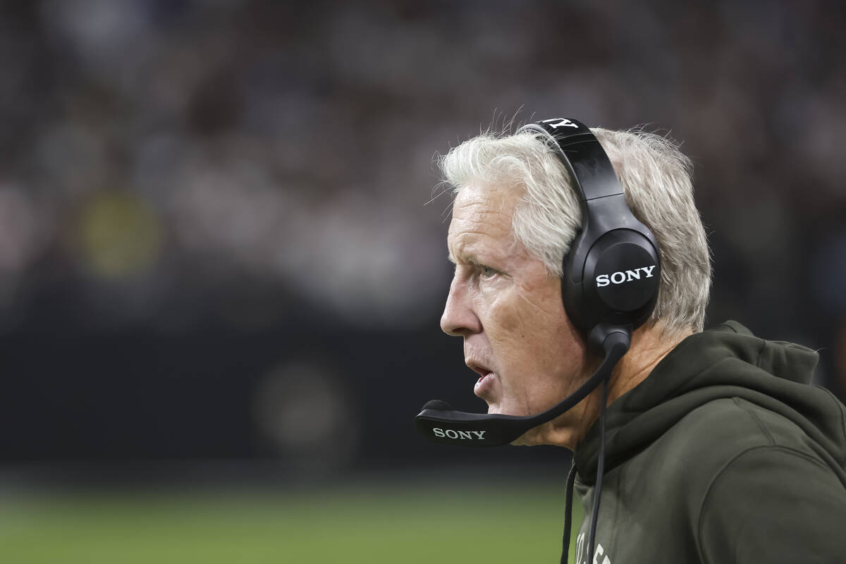 Raiders head coach Pete Carroll speaks into his microphone during the second half of a ” ...