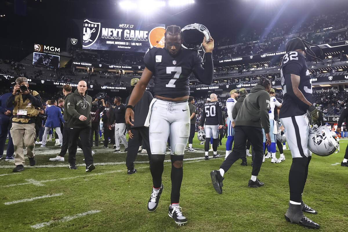 Raiders quarterback Geno Smith (7) takes his helmet off as he walks off the field after losing ...