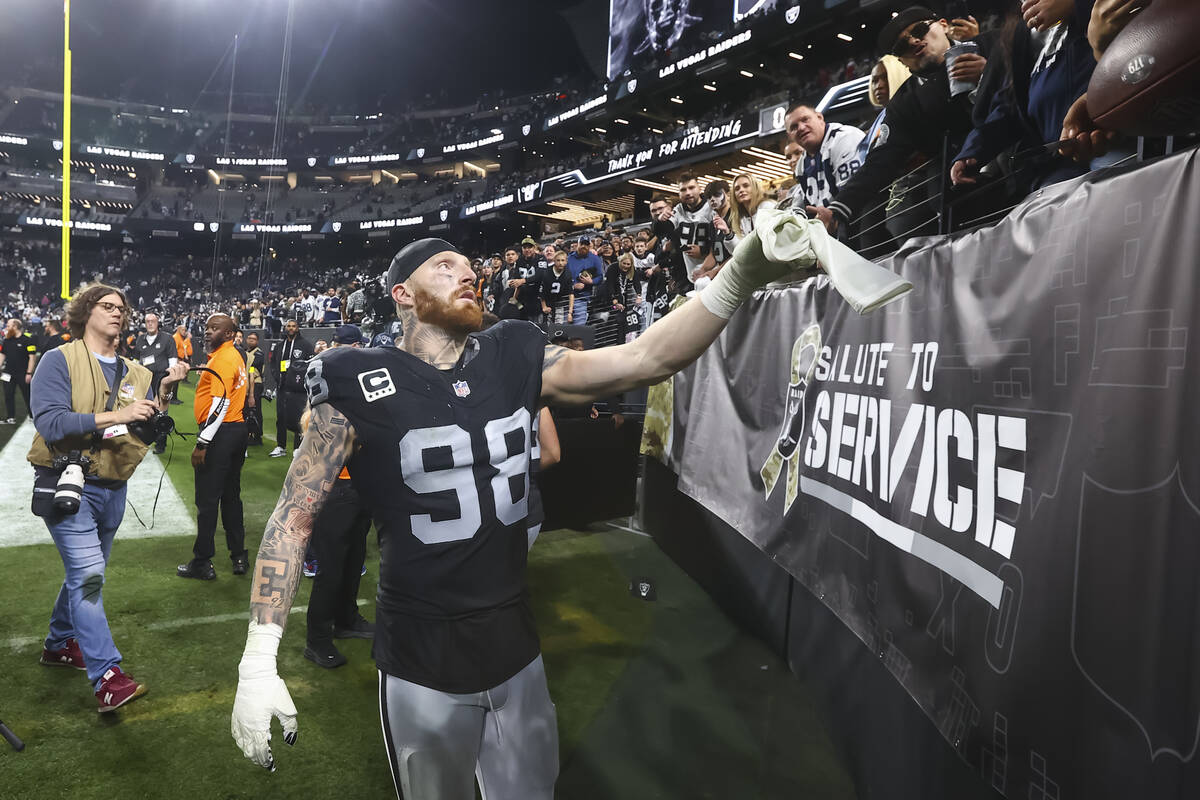 Raiders defensive end Maxx Crosby (98) hands a glove to a fan after a ”Monday Night Foot ...