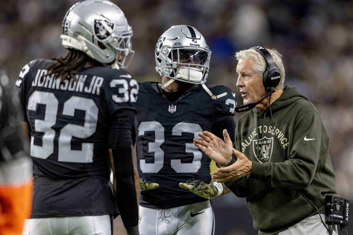 Raiders head coach Pete Carroll gives instruction to safety Lonnie Johnson (32) and linebacker ...