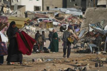 A man Palestinian man carries bags of firewood after collecting them from the rubbish in Khan Y ...