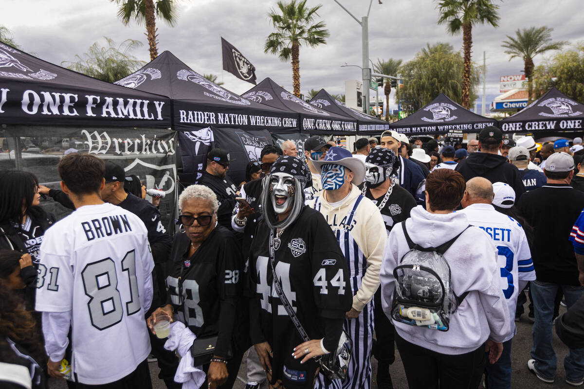 Raiders and Dallas Cowboys fans walk through the tailgate area before the start of a "Mond ...