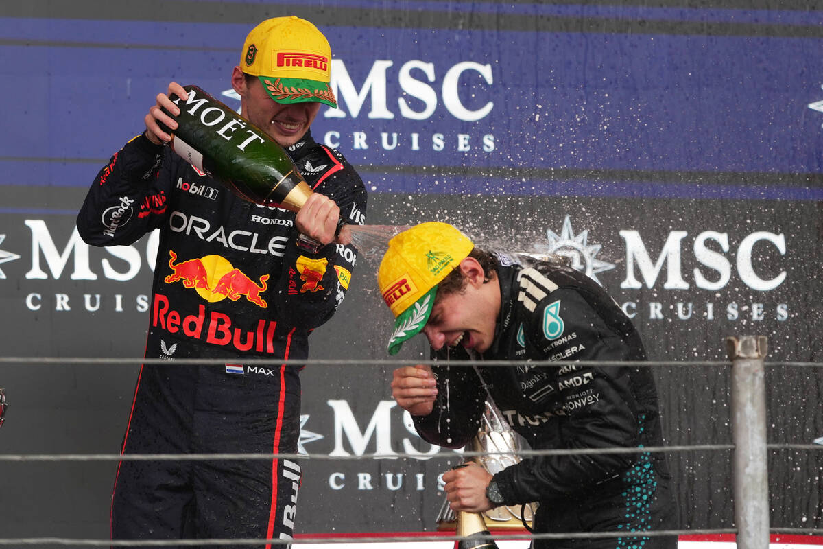 Red Bull driver Max Verstappen of the Netherlands, left, sprays champagne on Mercedes driver Ki ...