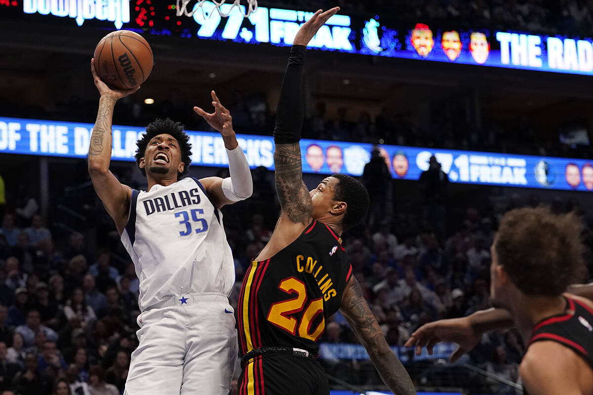 Dallas Mavericks forward Christian Wood (35) shoots against Atlanta Hawks forward John Collins ...
