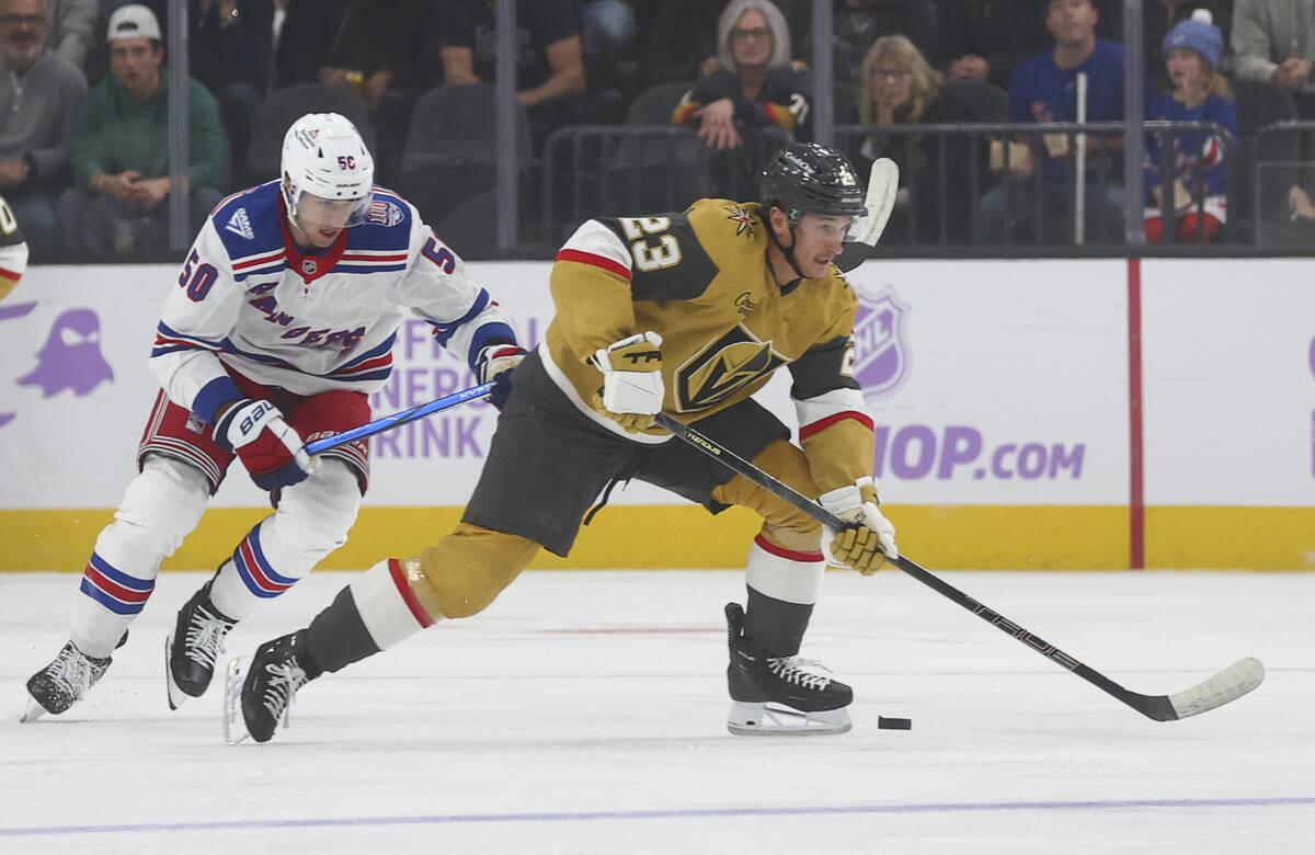 Golden Knights left wing Cole Reinhardt (23) skates with the puck under pressure from New York ...