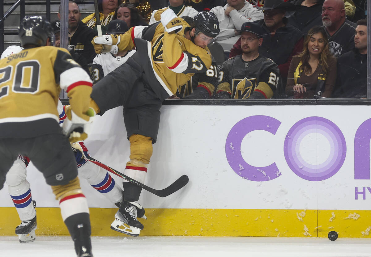 Golden Knights defenseman Ben Hutton (17) gets caught up with New York Rangers center Juuso Par ...
