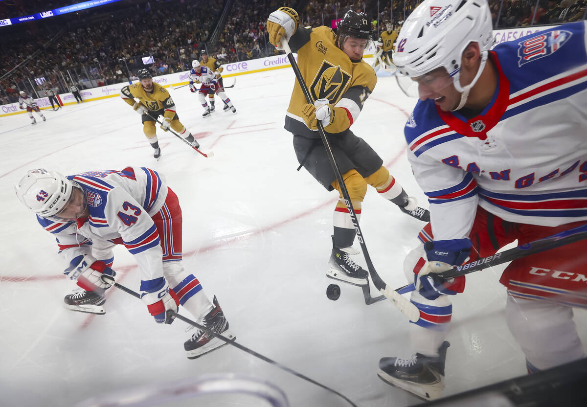 Golden Knights defenseman Ben Hutton (17) tries to get the puck from New York Rangers left wing ...