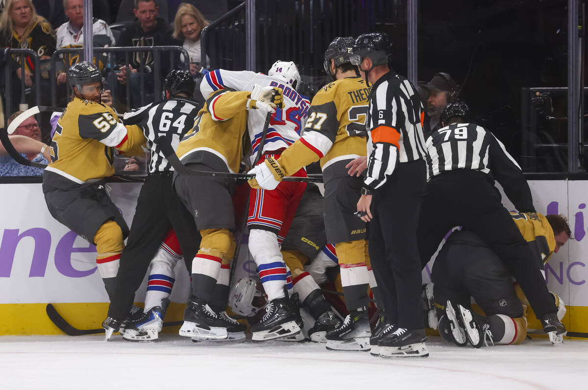 Golden Knights players fight the New York Rangers as linesmen Greg Devorski (54) and Kiel Murch ...